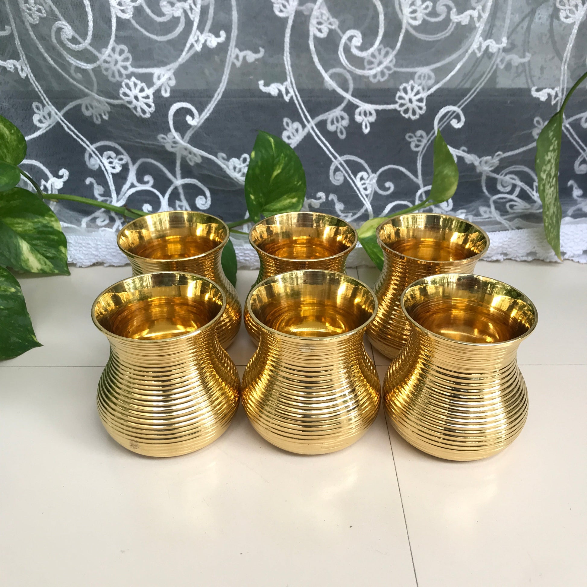 Brass Damru tumbler set of 6 with large and small sizes.