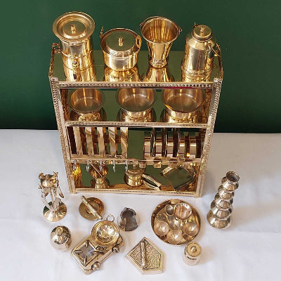 Collection of gold decorative items on a white surface with a green background